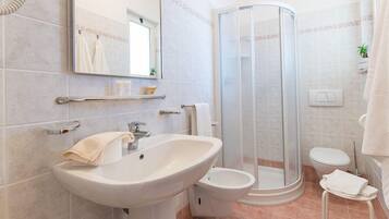 Une salle de bain moderne équipée d’un lavabo, de toilettes et d’une douche.