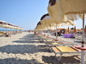 A beach with rows of sun loungers and thatched umbrellas. - Ristorante Hotel Lucia (Giulianova)