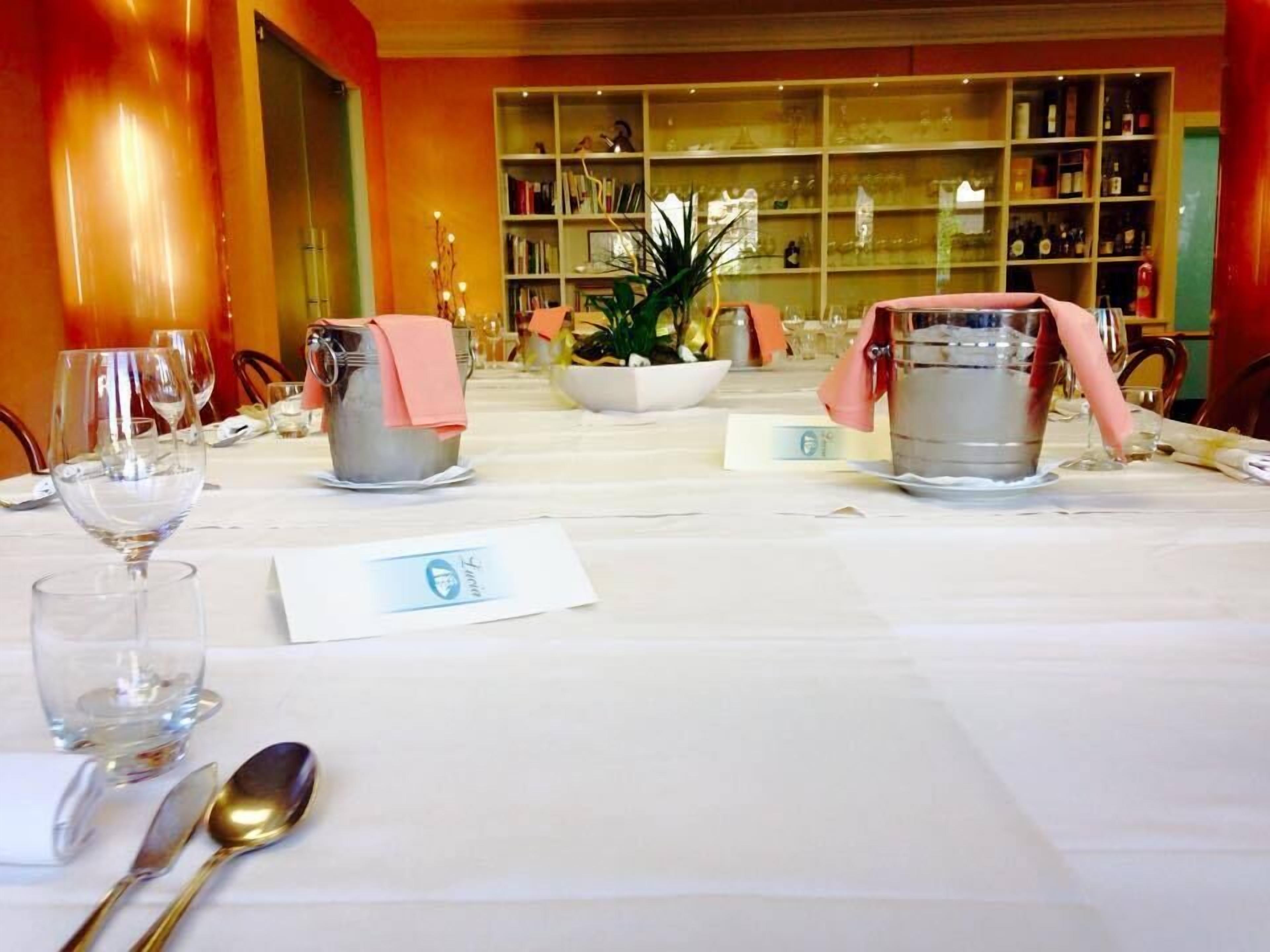 Una mesa de comedor preparada con copas de vino, un bol y un menú.