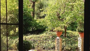 An outdoor dining area with a table set for four, surrounded by metal chairs, under a canopy. - La Pergola (Zibido San Giacomo)