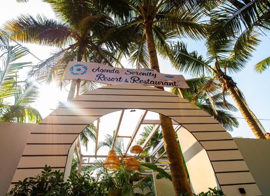 A sign for 'Agenda Serenity Resort & Restaurant' with a palm tree archway.