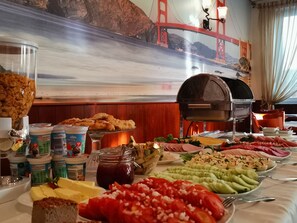 A buffet table with various food items and a grill. - Hotel Granada (Ostrow Wielkopolski)