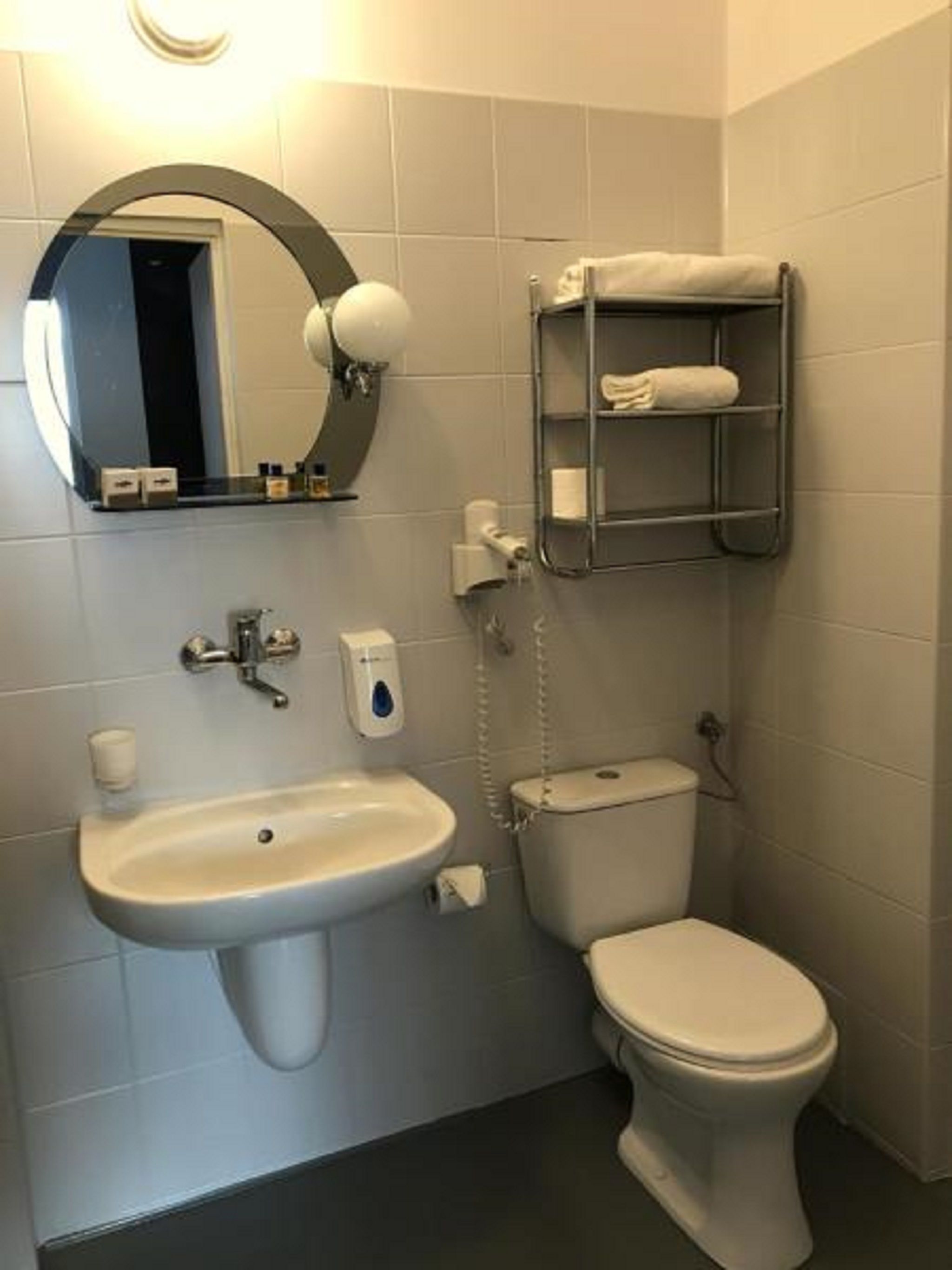 A bathroom with a sink, toilet, and a towel rack.