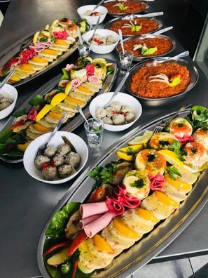 A buffet with various dishes including meats, vegetables, and sauces. - Hotel Granada (Ostrow Wielkopolski)