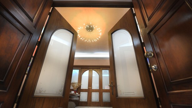 A grand wooden door with frosted glass panels and a decorative ceiling light. - Hotel Piccolo di Corduneanu Aurora (Termini Imerese)