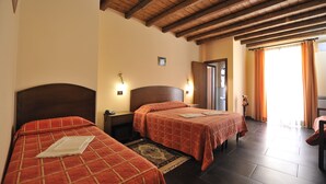 A hotel room with two beds, wooden ceiling beams, a nightstand, and a view of the outdoors. - Hotel Piccolo di Corduneanu Aurora (Termini Imerese)