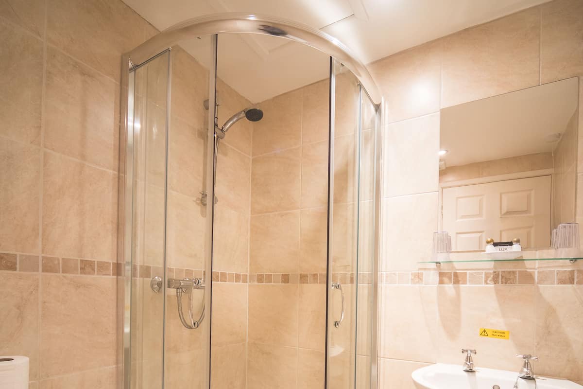 Une salle de bain avec une douche à parois de verre, un lavabo et des toilettes.