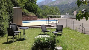 An outdoor patio with a pool, surrounded by mountains. - Hotel Escalar (Panticosa)