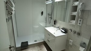 A modern bathroom with a glass-enclosed shower, a white sink, and a mirror above it. - Hotel Corveyer Hof (Hoexter)