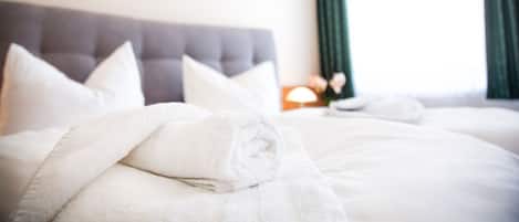 Ein Hotelzimmer mit einem großen Bett, einem Kopfteil und einem Nachttisch mit einer Lampe.