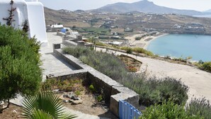 A coastal landscape with a stone pathway leading to a beach. - Andromeda Mykonos Villas & Suites (Mykonos)