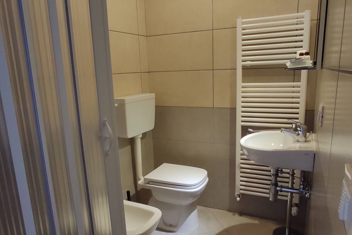 A modern bathroom with a toilet, bidet, and sink.
