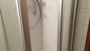 A small, enclosed shower area with a glass door and a showerhead. - Pension Vier Tore (Neubrandenburg)