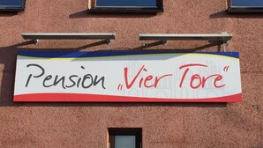 A building with a sign that reads "Pension Vier Tore". - Pension Vier Tore (Neubrandenburg)