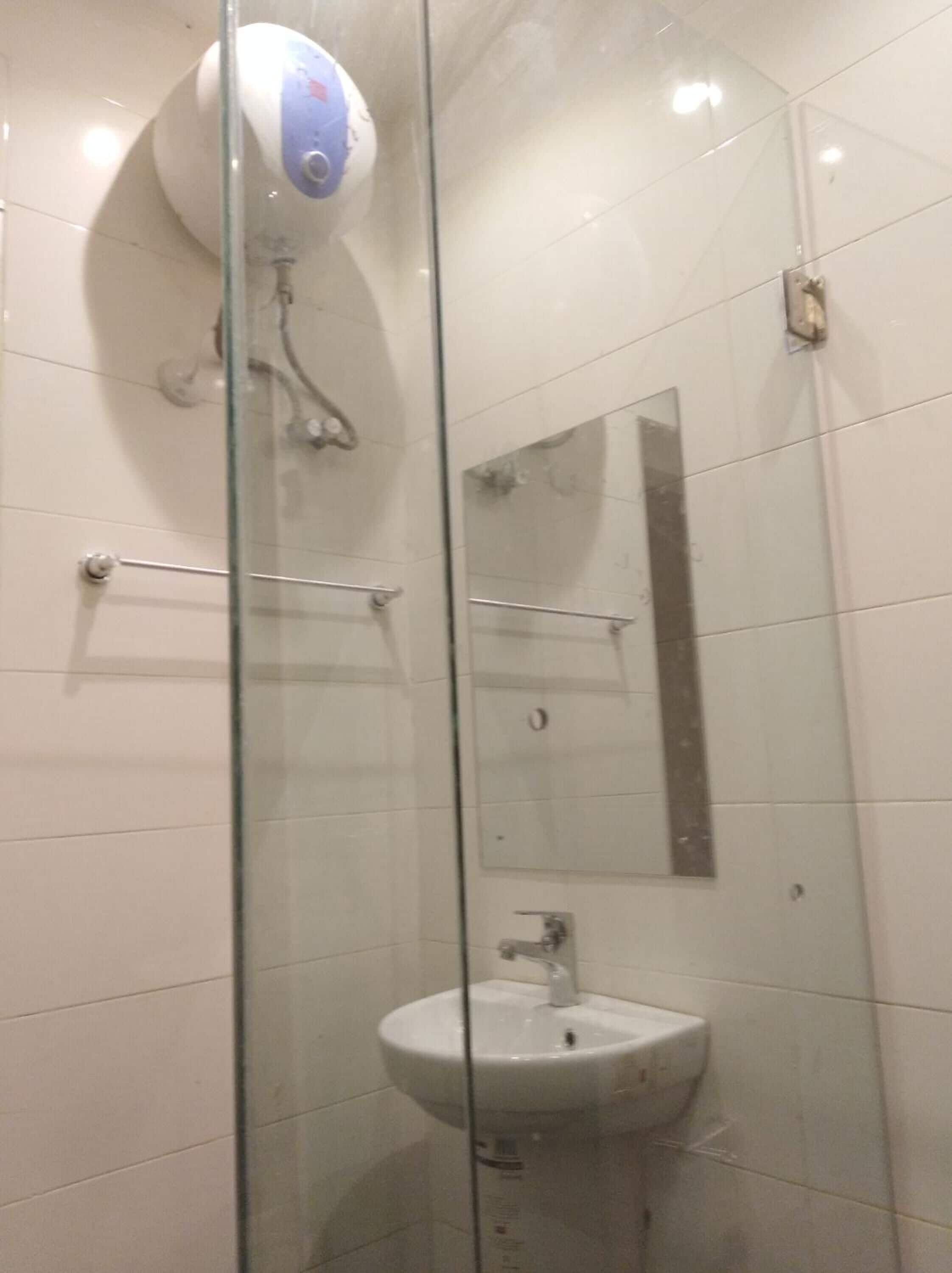 A glass-enclosed shower stall with a white sink and a mirror.
