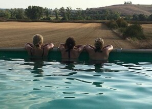 Una piscina al aire libre de temporada, sombrillas