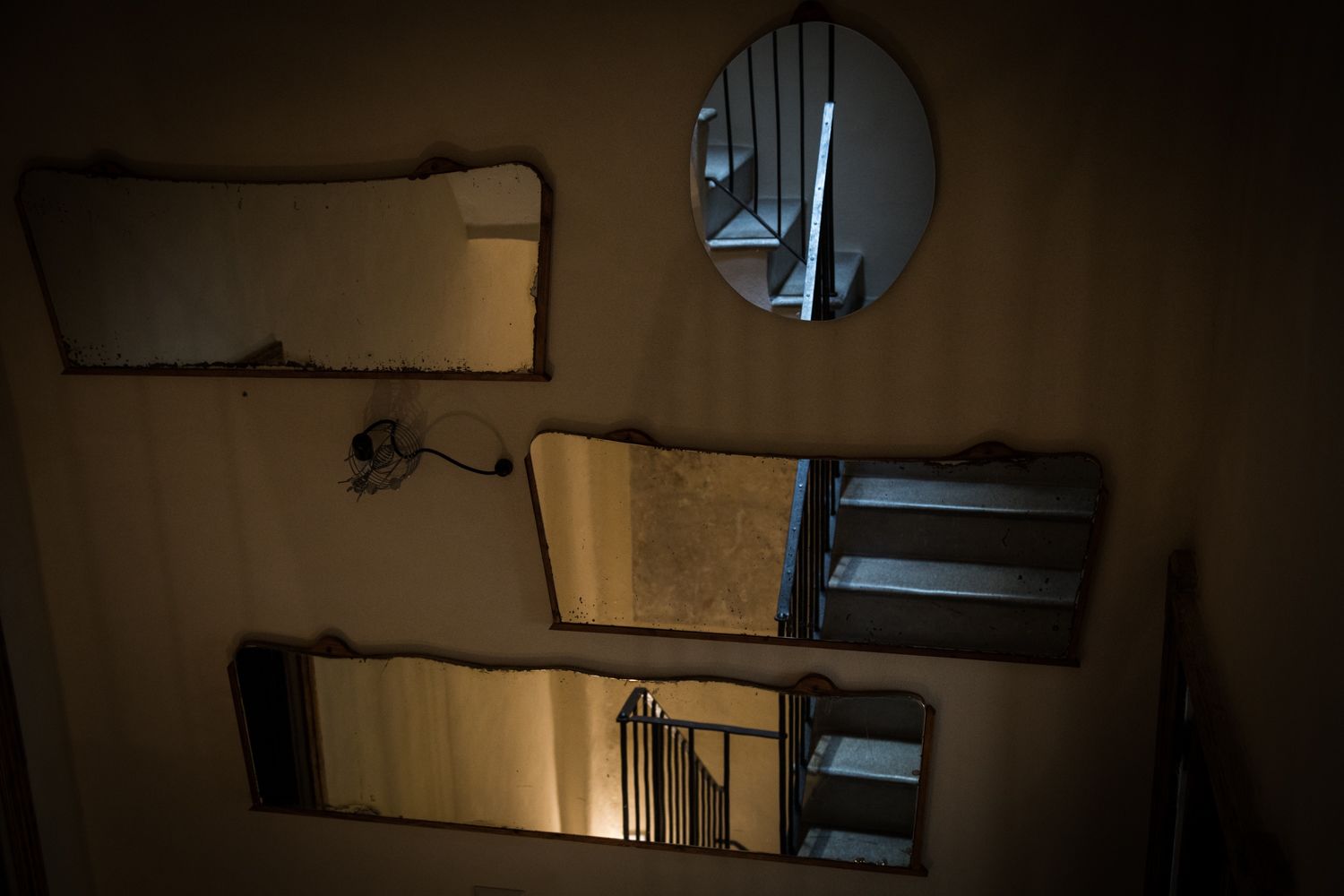 Una pared con varios espejos y un espejo circular.
