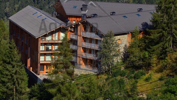 A multi-story lodge with balconies, set in a forested area. - Ski-in/Ski-out Apt: Balcony, Parking, 7 Min Walk to Shops, Sleeps 4 (Bellentre)