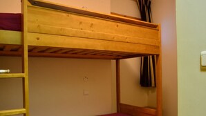 A bunk bed with a wooden frame and a purple mattress. - Ski-in/Ski-out Apt: Balcony, Parking, 7 Min Walk to Shops, Sleeps 4 (Bellentre)