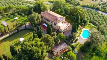 Un'ampia dimora con piscina, immersa nel verde e circondata da un prato curato.