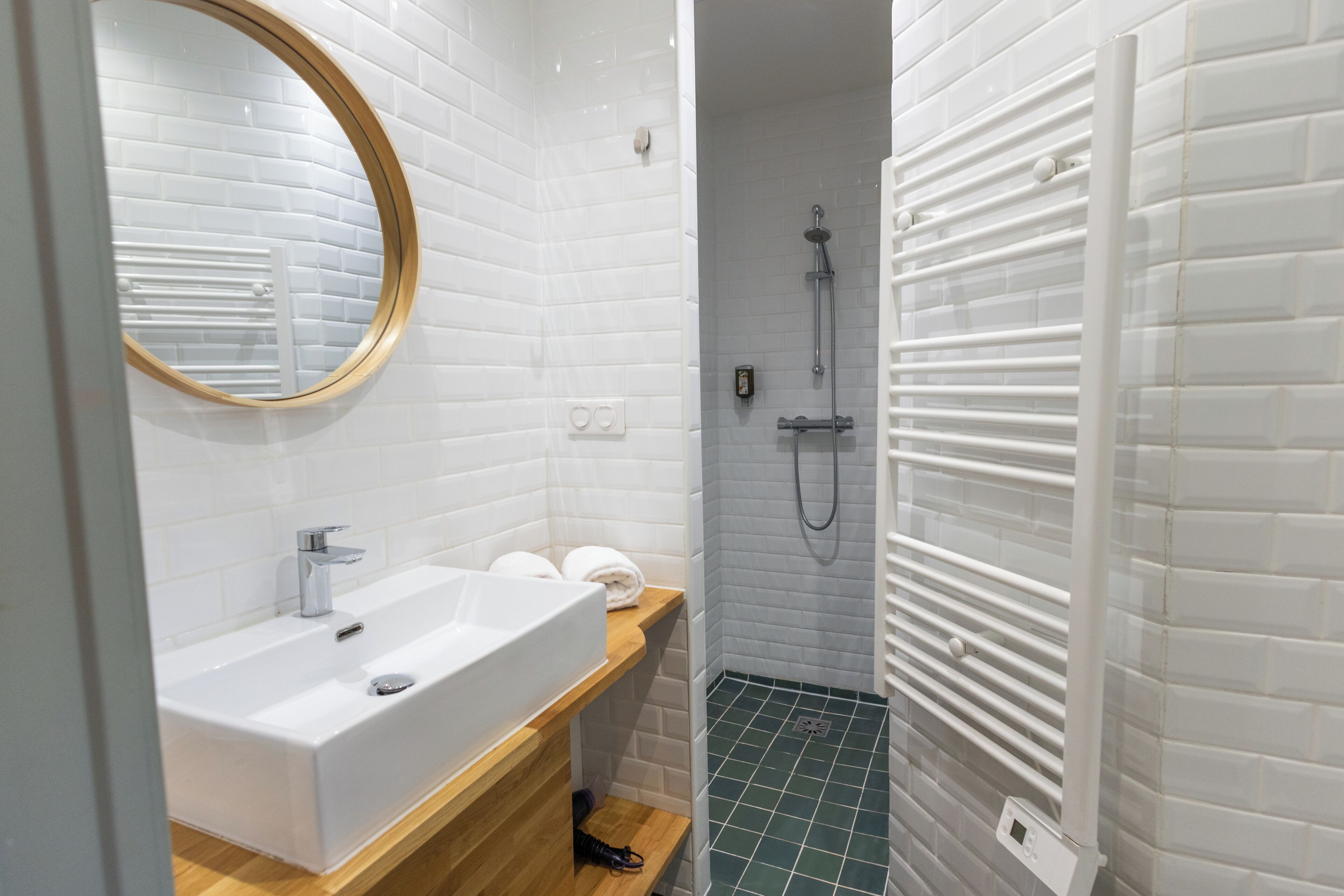 A bathroom with a white sink, mirror, and shower.