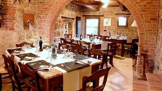 Un restaurant aux murs de briques, aux tables et aux chaises en bois.