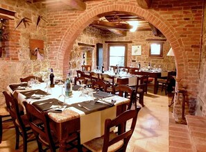 A restaurant with brick walls, wooden tables, and chairs. - Verdidea - Podere della Bruciata (Chiusi)