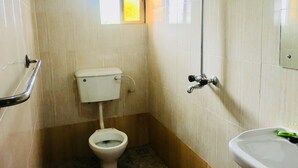 A small bathroom with a toilet, a shower, and a sink. - Cossy Hotel & Suite (Agbor)