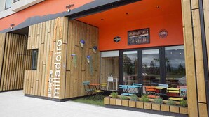 Un edificio moderno con fachada de madera y mobiliario exterior colorido.