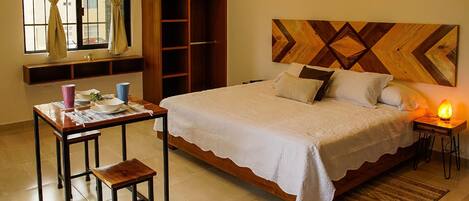 A bedroom with a bed, bedside table, lamp, and a wardrobe.