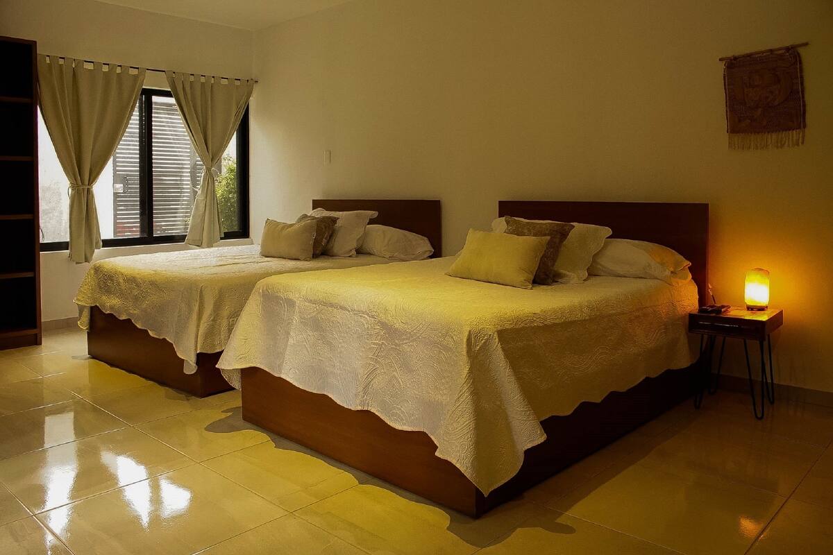 Una cama doble con cabecera de madera y mesita de noche con lámpara.