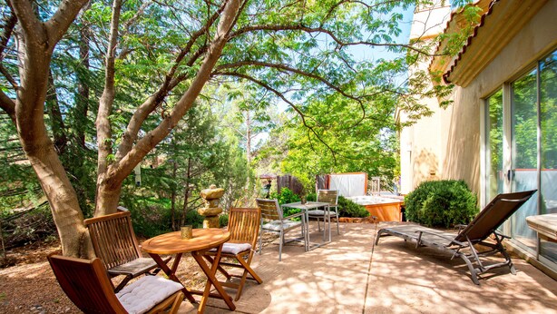 Une terrasse extérieure avec des meubles en bois, une table et des chaises.