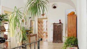 Amplia sala de estar con techo alto, una escalera y un armario de madera.