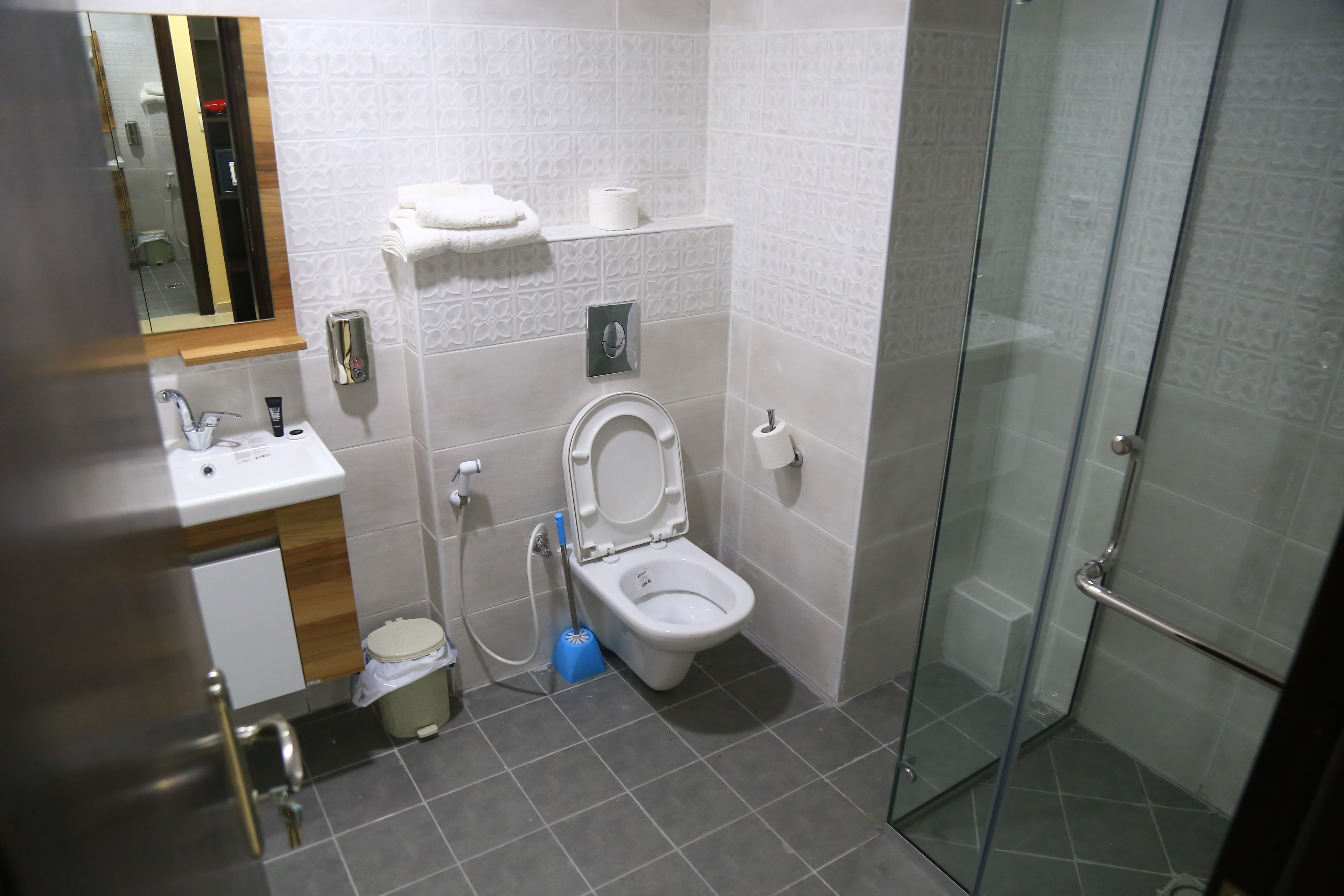 A modern bathroom with a toilet, sink, and glass shower enclosure.