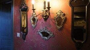 Een muur met decoratieve wandklemmen, een spiegel en sierlijsten.