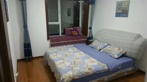 Een slaapkamer met een bed, een raam en een gordijn.