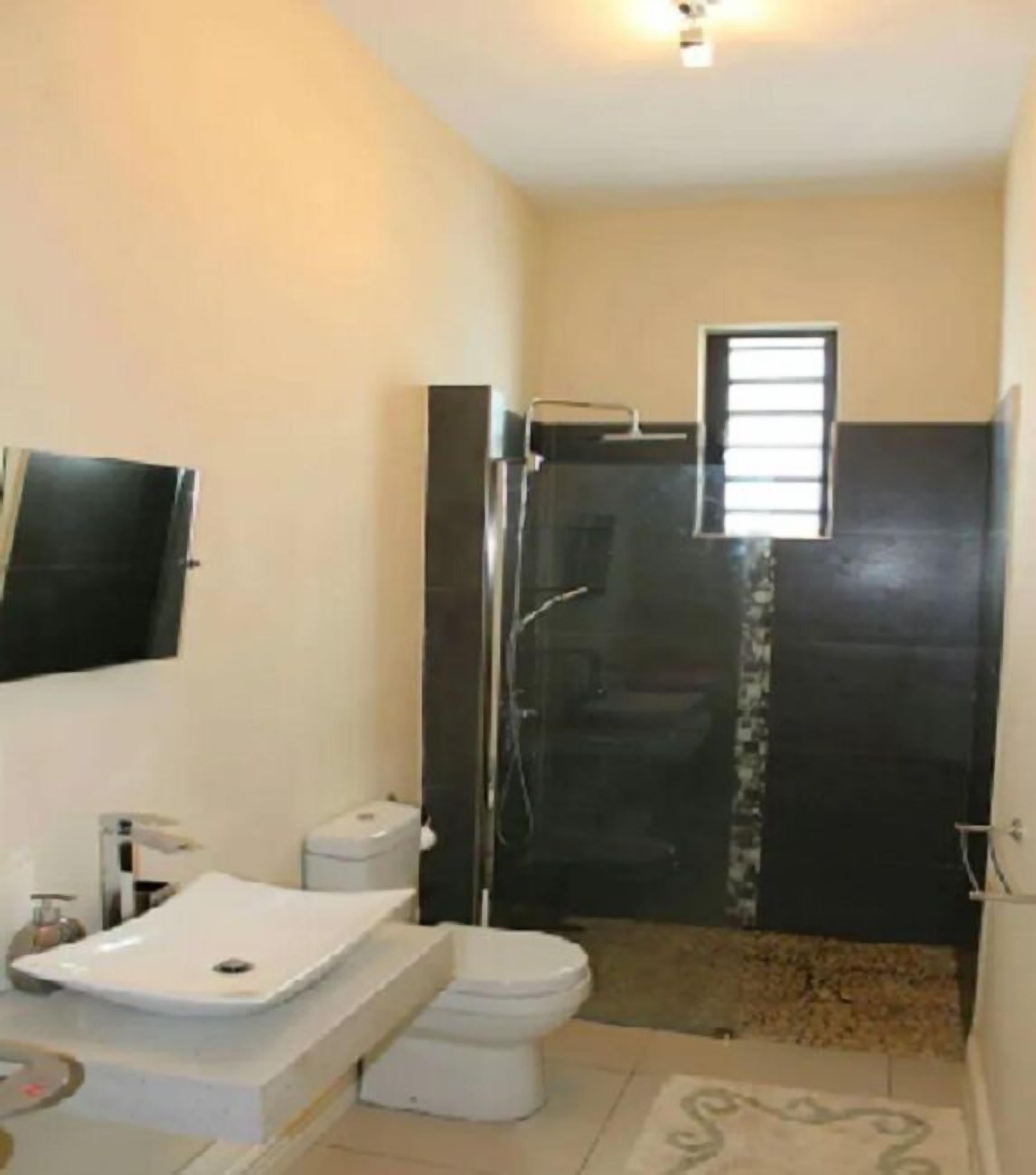A bathroom with a toilet, sink, and shower.