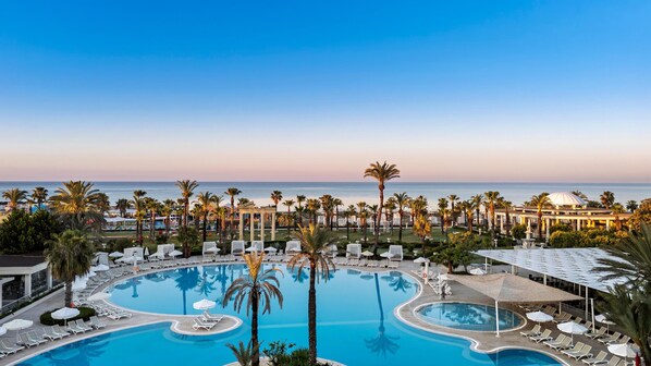 Una piscina techada, 2 piscinas al aire libre, sombrillas