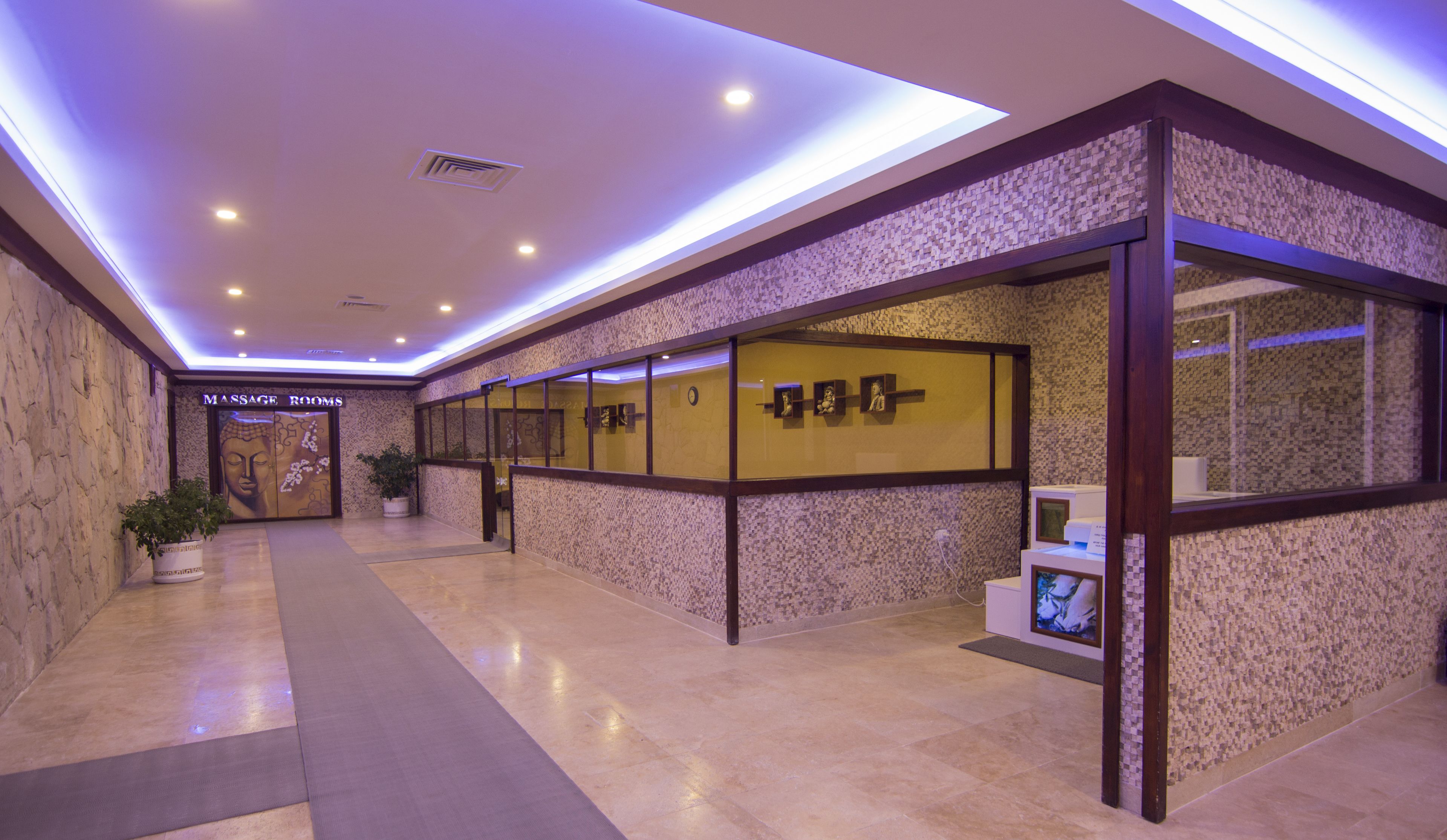 A modern interior with a massage room, a reception desk, and a wall with framed pictures.
