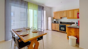 A modern kitchen with wooden cabinets, a microwave, oven, and a sink.