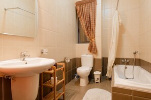 Ein Badezimmer mit Waschbecken, Toilette und Badewanne.