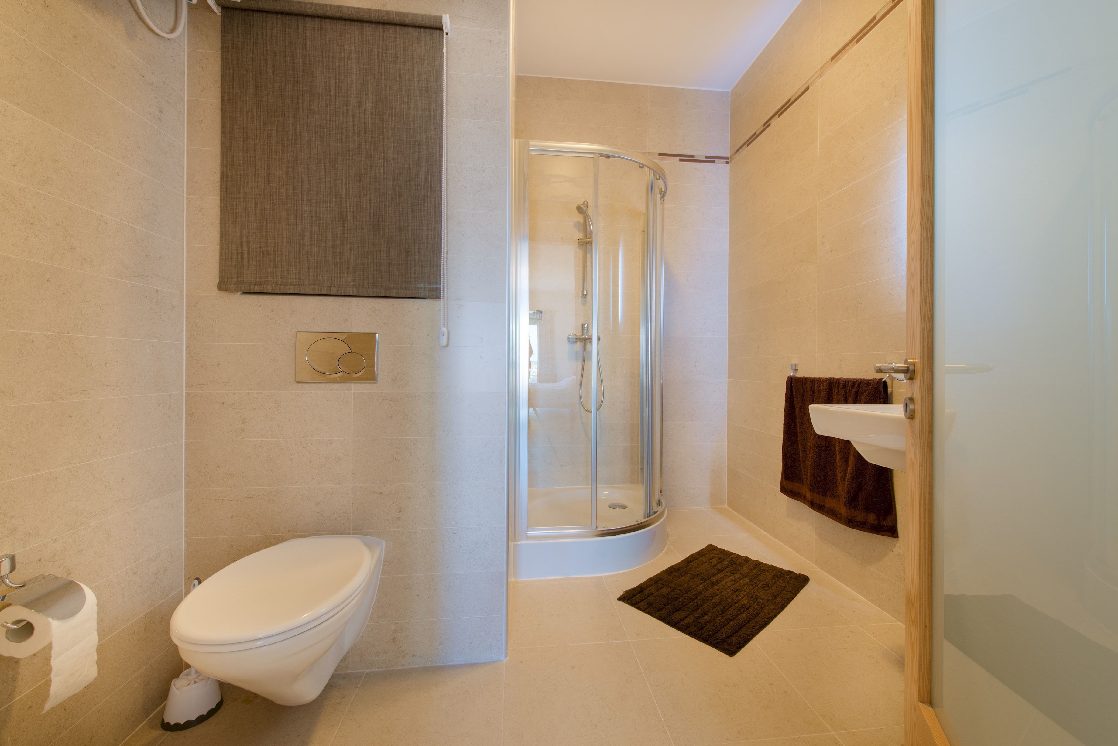 Une salle de bain moderne équipée de toilettes, d’une douche et d’un lavabo.