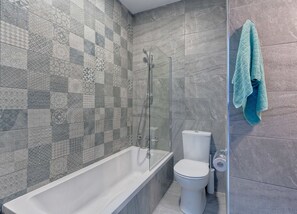 Un bagno con vasca, servizi igienici e cabina doccia in vetro.