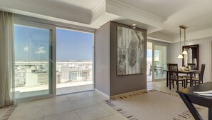 A spacious living room with a large sliding glass door leading to a balcony with a city view. - Luxury Apartment inc Pool & Views (Sliema)