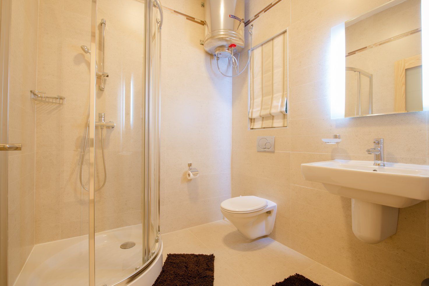 Une salle de bain moderne dotée d’une douche à parois de verre, de toilettes et d’un lavabo.