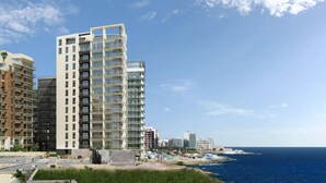 A modern high-rise building with multiple balconies, situated near a coastline. - Seaview APT Incl Pool IN Sliema (Sliema)