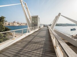 Fußgängerbrücke mit Blick auf eine Stadt und Wasser.