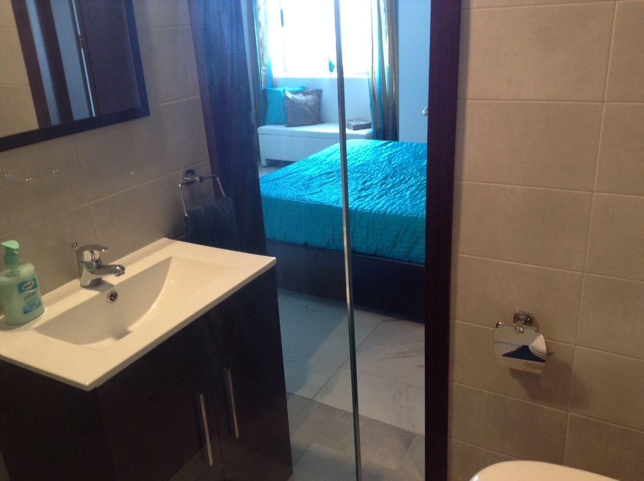 Een badkamer met een wastafel, spiegel en toilet.