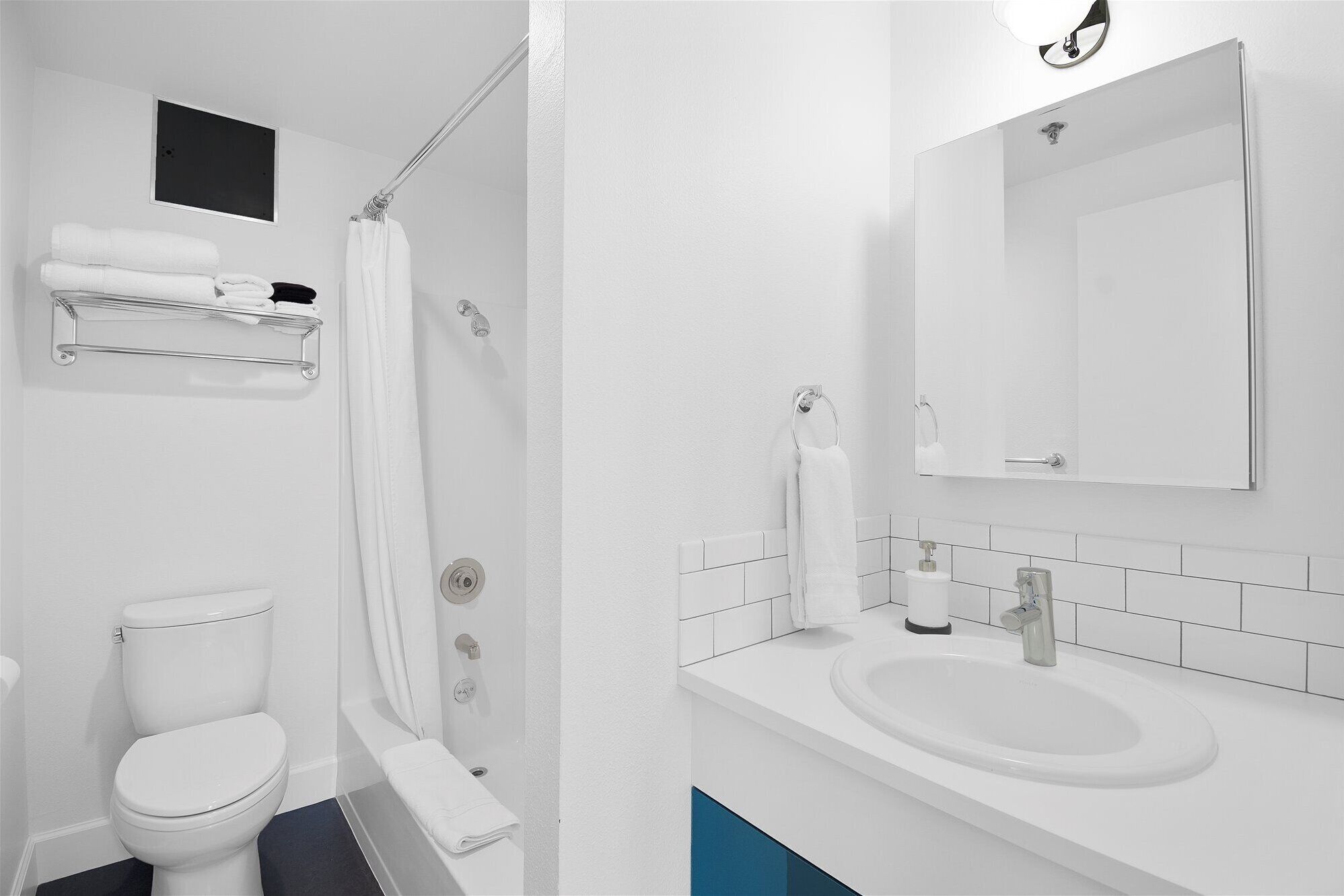 A modern bathroom with a toilet, shower, and sink.