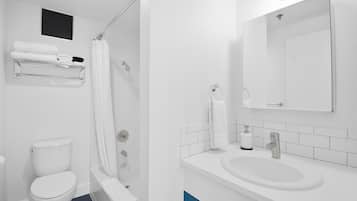 A modern bathroom with a toilet, shower, and sink.